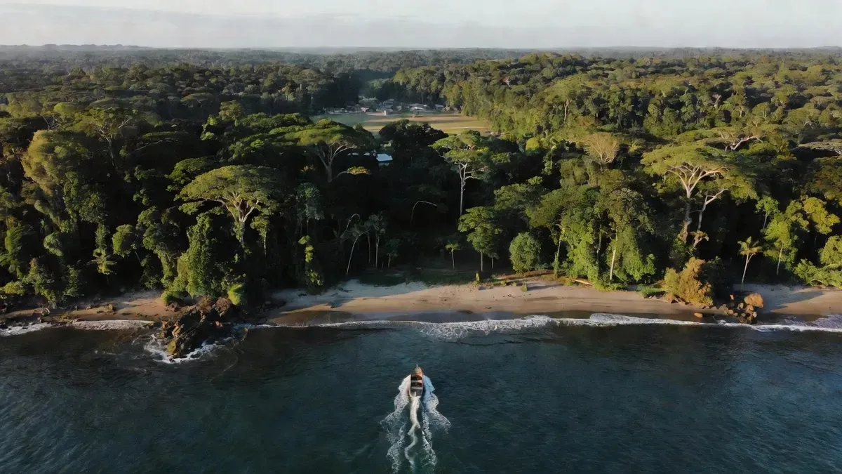 Aerial view of the Osa Peninsula coastline in Costa Rica showing the three entry points to Corcovado National Park — Drake Bay, Puerto Jimenez, and Uvita — with primary rainforest meeting the Pacific Ocean